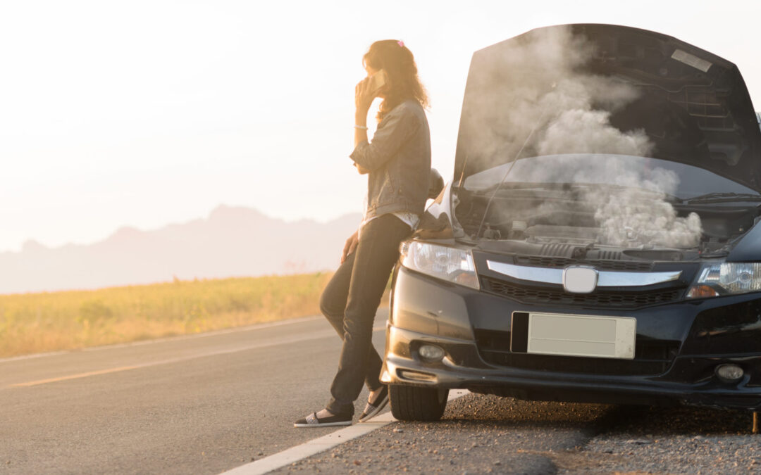 Broken car. Lady standing on the road by the broken car in the middle of nowhere. Making telephone call to get help with the broken car. smoke coming out the engine. Help needed. Car service.