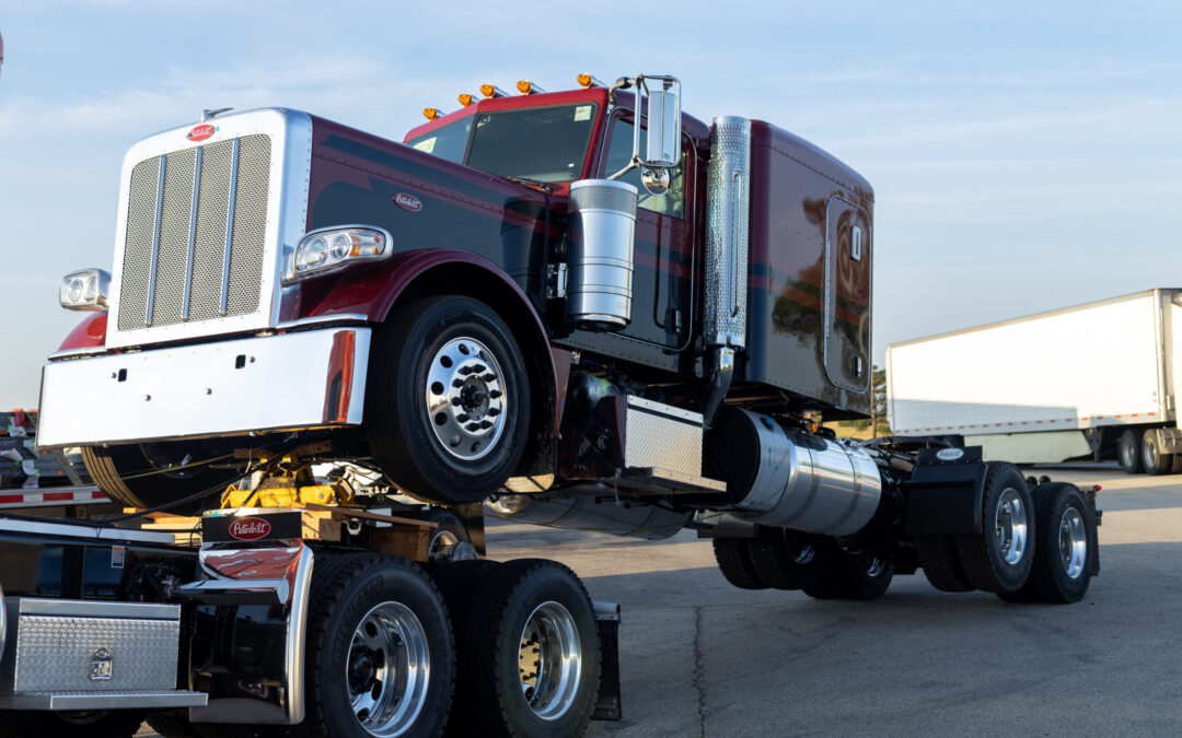 Port Arthur, Texas, USA – 09.11.2023: Semi Trucks Parked in a Row at Truck Stop During Dusk. Red Semi Truck Towed on a Trailer at Truck Stop